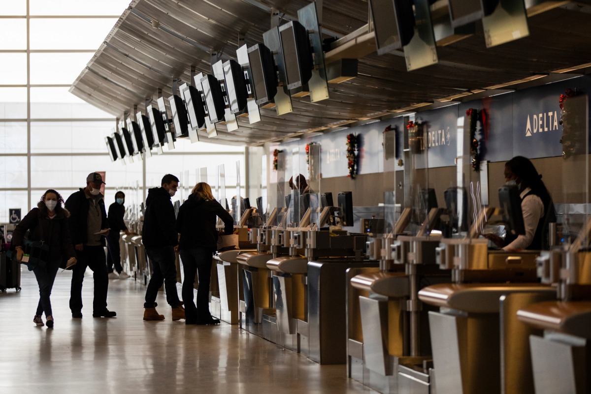 Travelers check in for their flights at Detroit Metropolitan Wayne County Airport, amid the coronavirus disease (COVID-19) pandemic, in Romulus, Michigan, U.S., December 24, 2020. REUTERS/Emily Elconin
