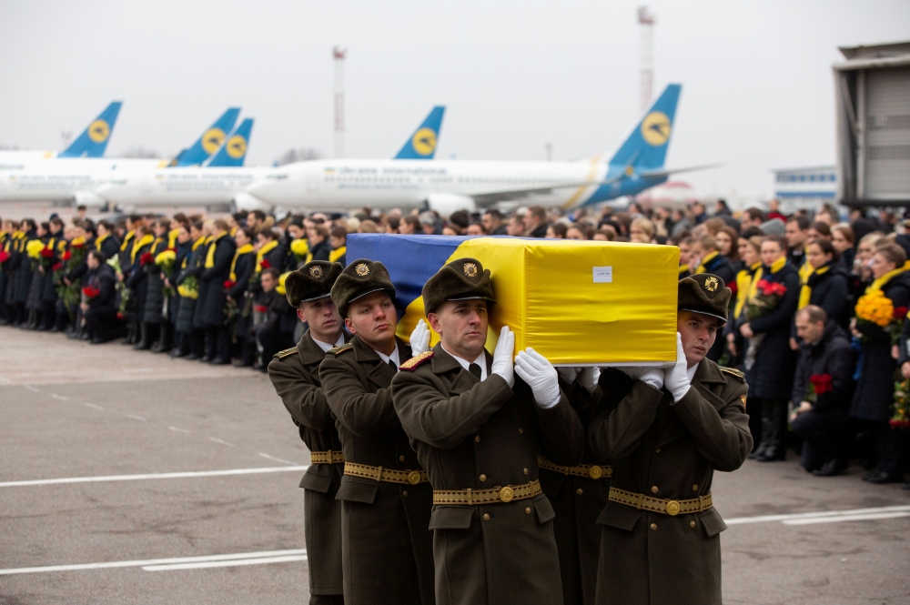 FILE PHOTO: Soldiers carry a coffin containing the remains of one of the eleven Ukrainian victims of the Ukraine International Airlines flight 752 plane disaster during a memorial ceremony at the Boryspil International Airport, outside Kiev, Ukraine Janua