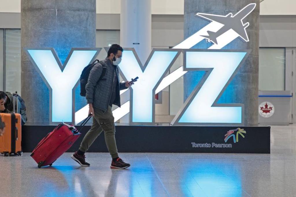 FILE PHOTO: A traveller passes a YYZ airport code sign in the international arrival lounge amid a growing global number of coronavirus cases at Pearson Airport in Toronto, Ontario, Canada March 13, 2020. REUTERS/Chris Helgren
