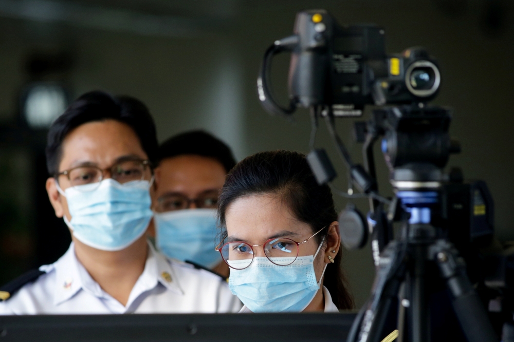 Airport personnel monitor a thermal scanner as passengers arrive at the Ninoy Aquino International Airport in Pasay, Philippines, January 23, 2020. REUTERS/Eloisa Lopez/File Photo