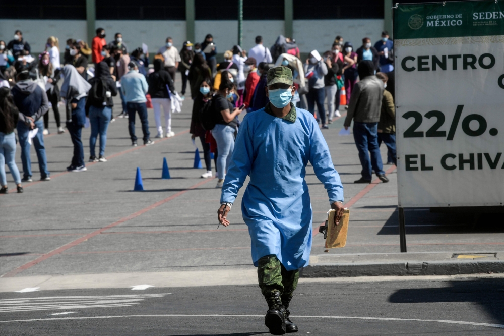 Health workers queue to receive the Pfizer/BioNTech COVID-19 vaccine jab, at the 22 Battalion of the Military Police Hospital in Mexico City, on December 30, 2020. Mexico has registered more than 124,000 coronavirus deaths -- the world's fourth-highest to