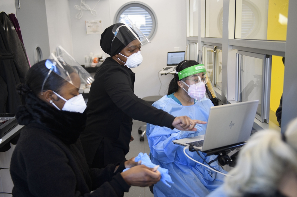 Lab staff wear personal protective equipment (PPE) while collecting tests from travelers in an on-site Covid-19 testing laboratory at Los Angeles International Airport (LAX) on December 31, 2020 in Los Angeles, California. AFP / Patrick T. Fallon
