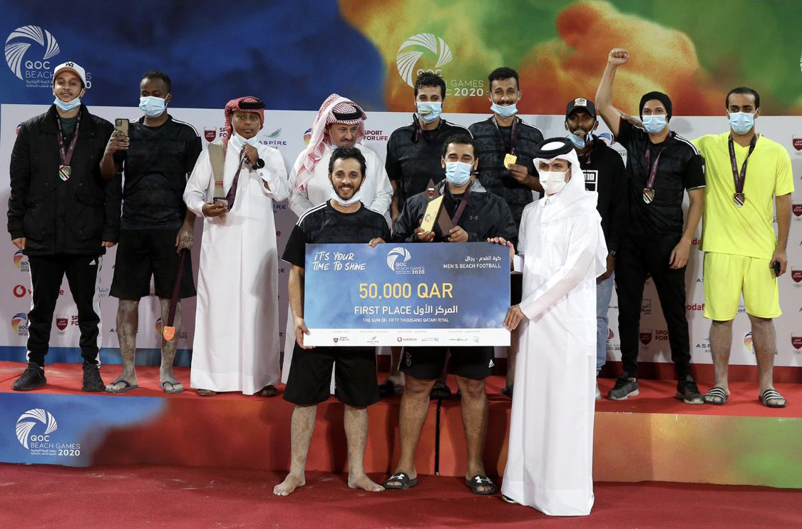 Qatar Olympic Committee (QOC) Secretary-General Jassim Rashid Al Buenain presenting the award to the winners of the beach football tournament, Al Shahaniya team members on the final day of the QOC Beach Games at Aspire Zone yesterday.