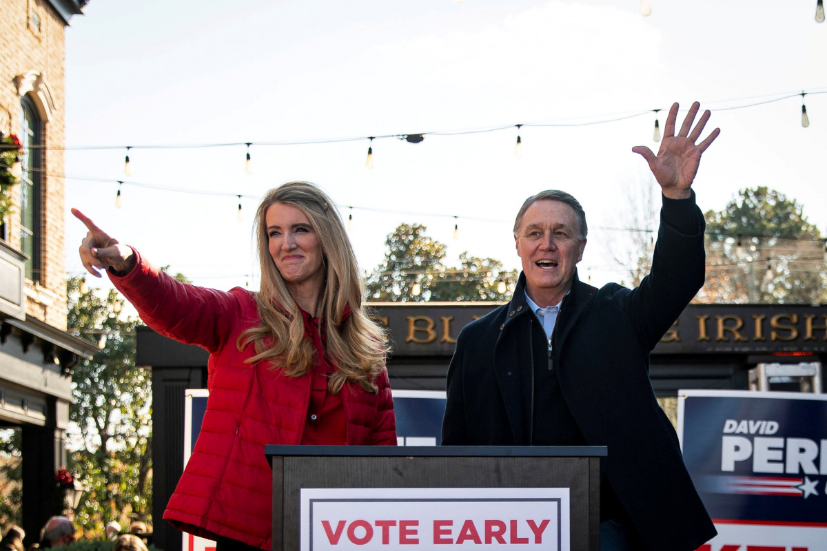 FILE PHOTO: Senator Kelly Loeffler (R-GA) and Senator David Perdue (R-GA), wave during a campaign event at the Olde Blind Dog Irish Pub, in Milton, Georgia, U.S., December 21, 2020.REUTERS/Al Drago/File Photo
