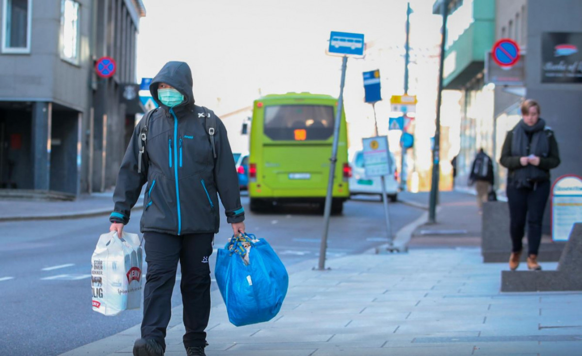 FILE PHOTO: A man wearing a protective mask carries shopping bags as he walks on the streets of Oslo following an outbreak of the coronavirus disease (COVID-19), in Oslo, Norway March 13, 2020. NTB Scanpix/Hakon Mosvold Larsen via REUTERS .
