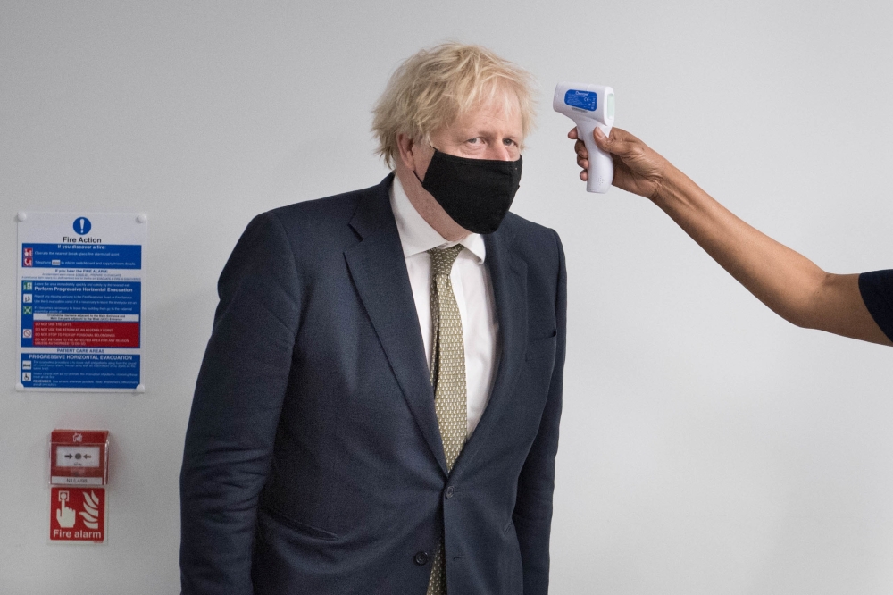 Britain's Prime Minister Boris Johnson has his temperature checked during a visit to Chase Farm Hospital in north London, Britain January 4, 2021. Stefan Rousseau/Pool via REUTERS