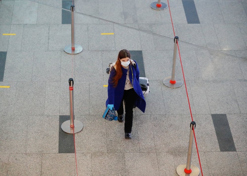 A woman wearing a protective mask walks at the departure zone of Vnukovo International Airport in Moscow, Russia December 30, 2020. REUTERS/Evgenia Novozhenina