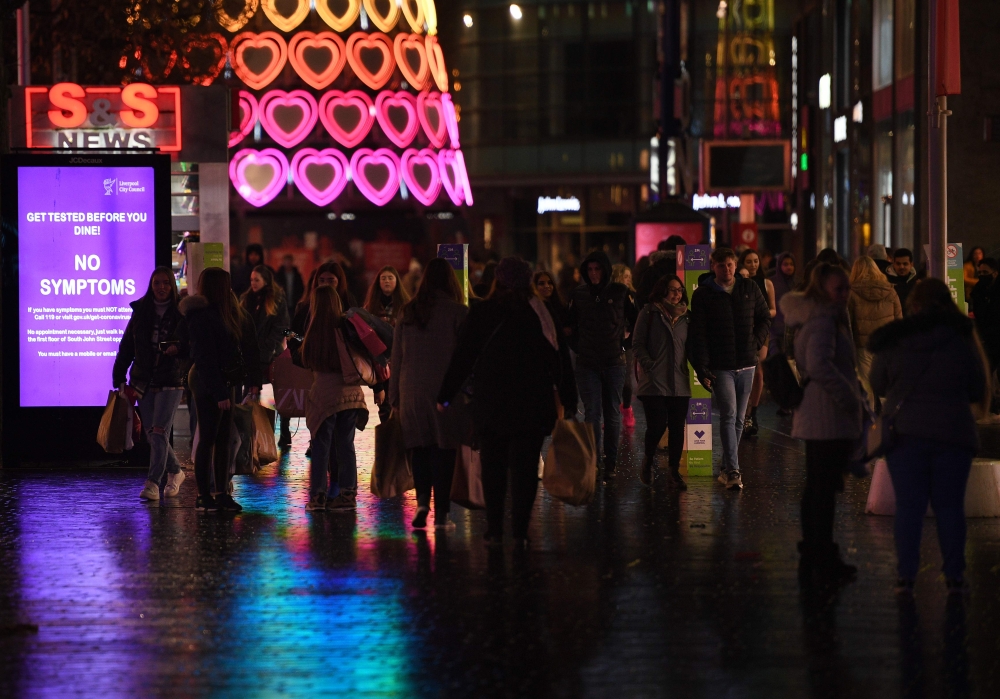 Pedestrians walk through central Liverpool, northwest England, on December 30, 2020 before thightened Tier 3 restrictions imposed in the city amid surging cases of the novel coronavirus. / AFP / Oli SCARFF
