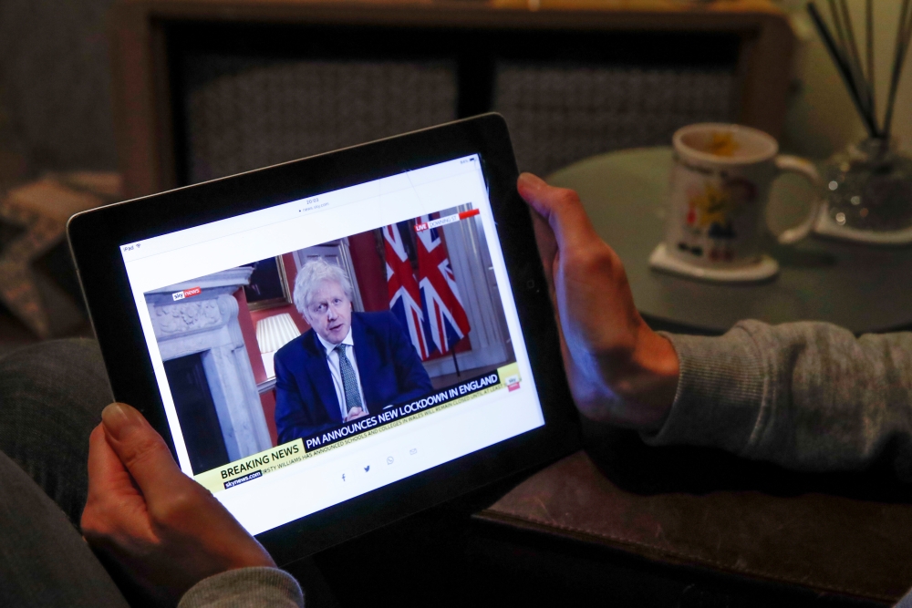 Teacher Wendy Couldridge watches on a device as Britain's Prime Minister Boris Johnson announces a lockdown in England, amid the coronavirus disease (COVID-19) outbreak, in Hertford, Britain, January 4, 2021. Reuters/Andrew Couldridge