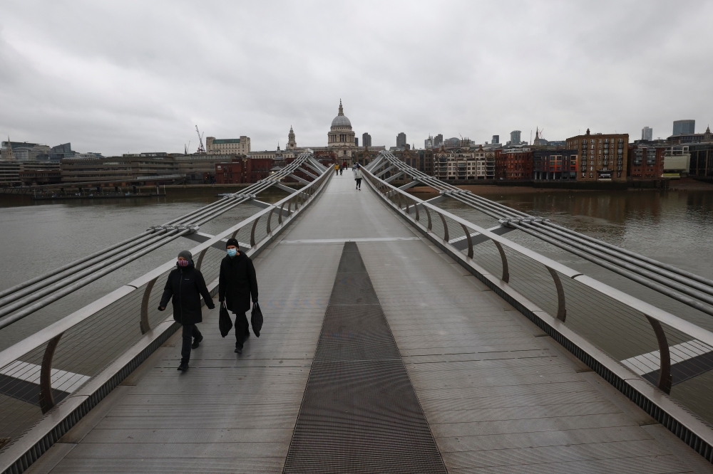 Pedestrians walk across The Millenium Bridge, amid the coronavirus disease (COVID-19) outbreak, in London, Britain, January 5, 2021. REUTERS/Henry Nicholls