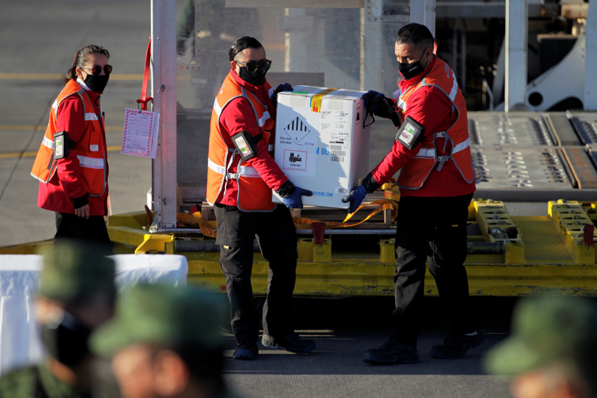 Workers unload a box with Pfizer/BioNTech COVID-19 vaccines to be transported to Saltillo, at the Mariano Escobedo International Airport, as the coronavirus disease (COVID-19) outbreak continues, in Apodaca, on the outskirts of Monterrey, Mexico January 5
