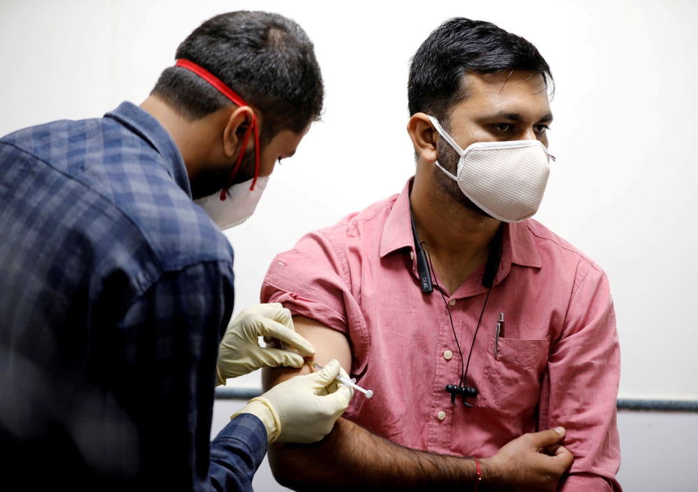A medic administers COVAXIN, an Indian government-backed experimental COVID-19 vaccine, to a health worker during its trials, at the Gujarat Medical Education & Research Society in Ahmedabad, India, November 26, 2020. Reuters/Amit Dave/File Photo