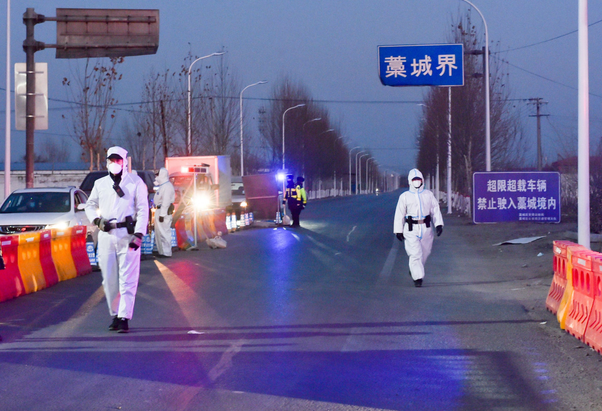 Police officers and staff members in protective suits inspect vehicles at a checkpoint on the borders of Gaocheng district on a provincial highway, following the coronavirus disease (COVID-19) outbreak in Hebei province, China January 5, 2021. Picture tak