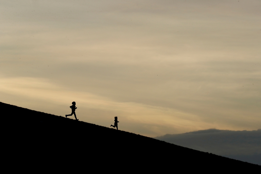 The silhouettes of two people jogging in the Phoenix Park, as the spread of the coronavirus disease (COVID-19) continues, in Dublin, Ireland, March 24, 2020. REUTERS/Jason Cairnduff/File Photo