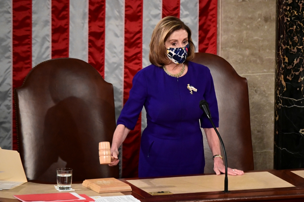 U.S. House Speaker Nancy Pelosi (D-CA) wears a protective mask while banging the Speaker's gavel during a joint session of Congress to count the Electoral College votes of the 2020 presidential election in the House Chamber in Washington, U.S., January 6,
