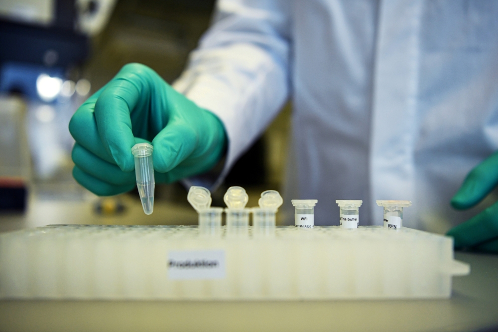 An employee of the German biopharmaceutical company CureVac demonstrates research workflow on a vaccine for the coronavirus (COVID-19) disease at a laboratory in Tuebingen, Germany, March 12, 2020. Reuters/Andreas Gebert/File Photo