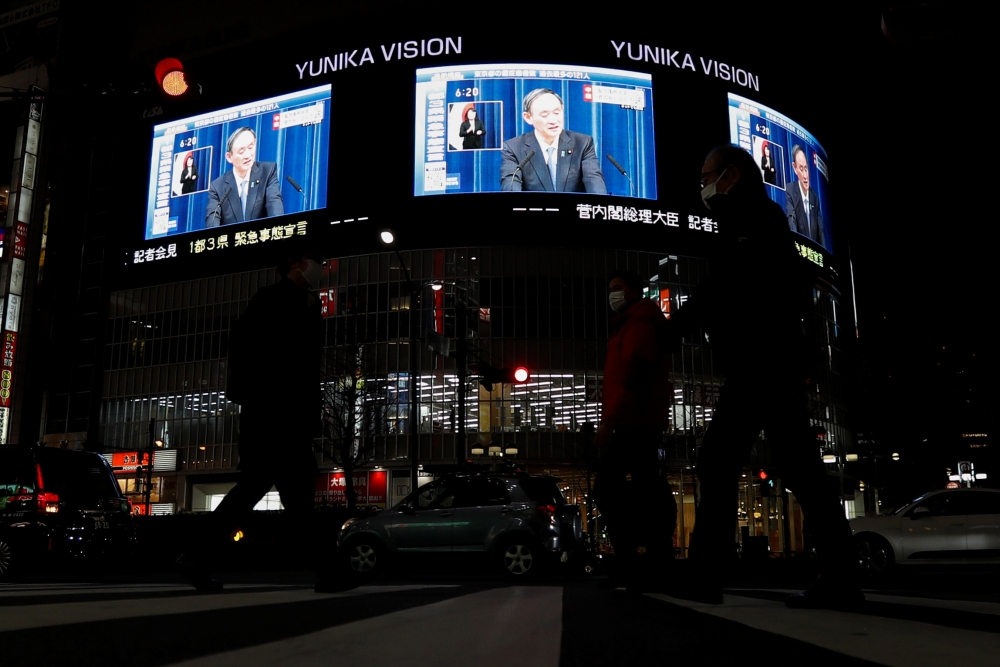 Large screens on a building show live broadcast of Japan's Prime Minister Yoshihide Suga declaring a state of emergency for Tokyo and three neighbouring prefectures in Tokyo, Japan January 7, 2021. Reuters/Issei Kato