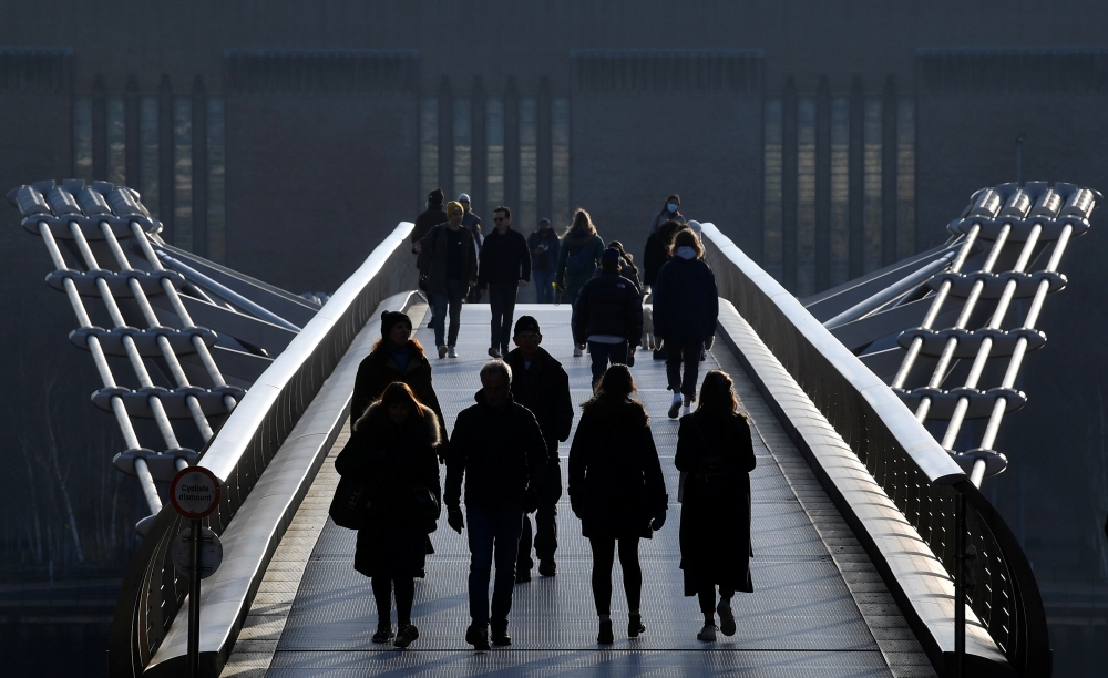 People walk over the Millennium footbridge amidst the COVID-19 pandemic, London, Britain, January 7, 2021. REUTERS/Toby Melville