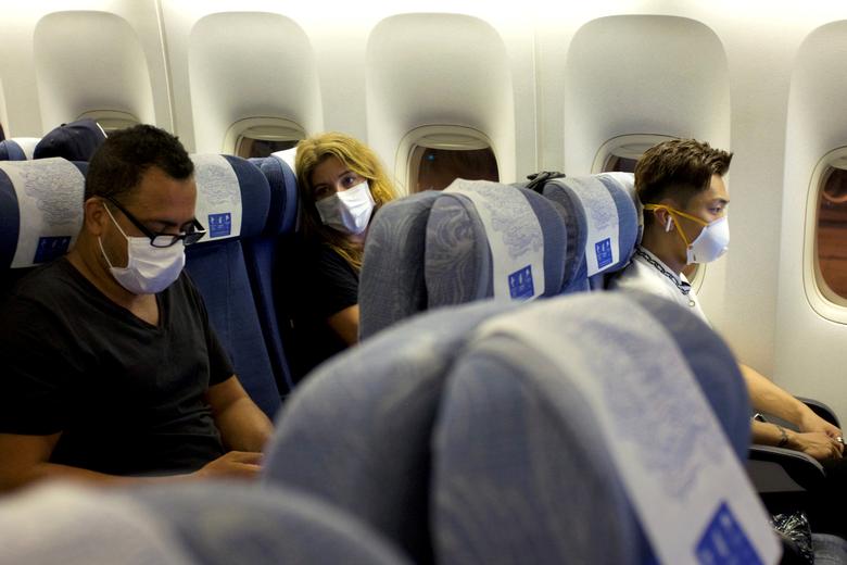 FILE PHOTO: Passengers wearing masks sit on an Air China flight from Sydney to Beijing before takeoff, in Sydney, Australia January 24, 2020. REUTERS/Thomas Peter

