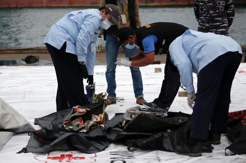 National Transportation Safety Commission (KNKT) officers inspect the debris of Sriwijaya Air flight SJ182, which crashed to the sea, at Tanjung Priok port in Jakarta, Indonesia, January 10, 2021. Reuters/Willy Kurniawan