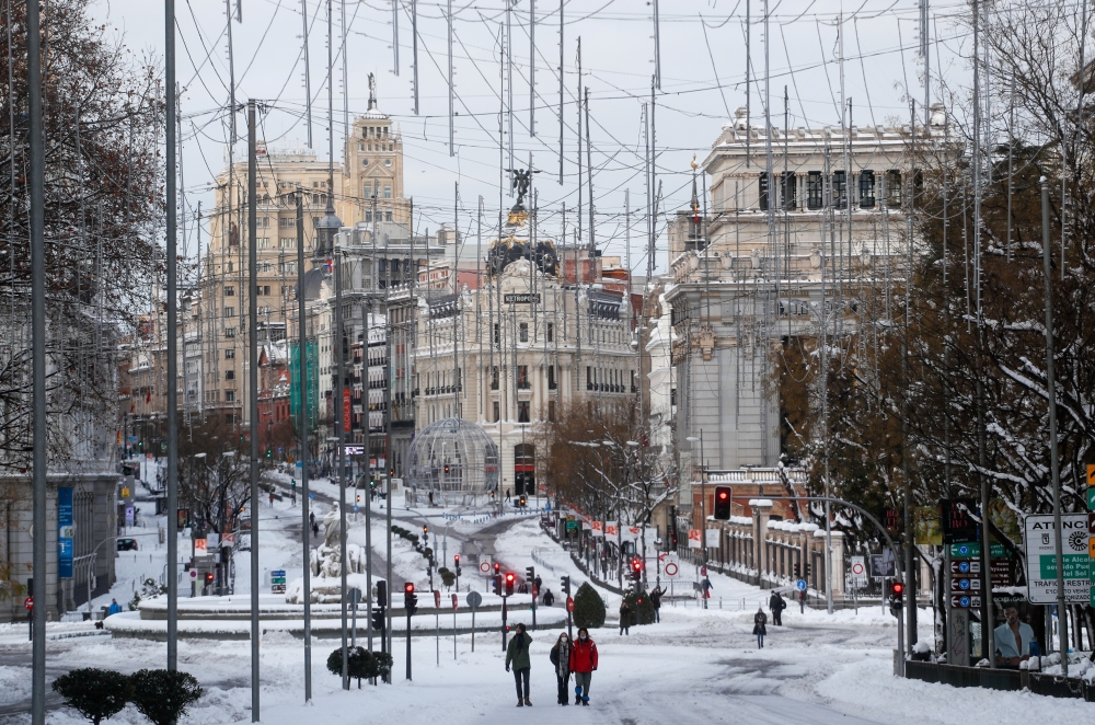 People walk in the snow, in downtown Madrid, Spain January 10, 2021. REUTERS/Susana Vera