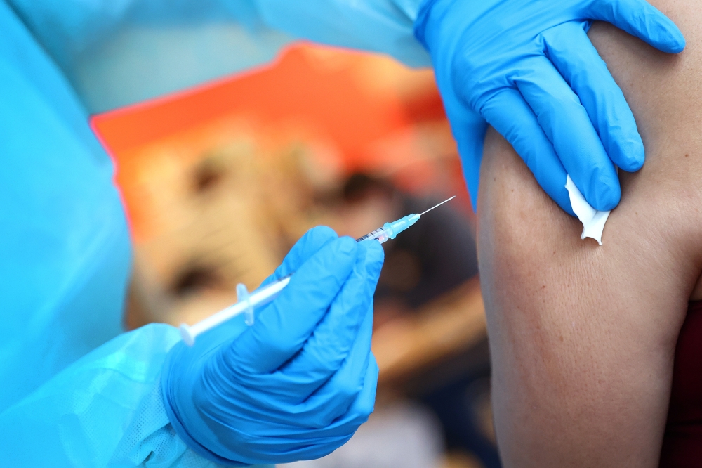 Corina Naujoks, member of a German Red Cross mobile vaccination team injects the Pfizer-BioNTech Covid-19 vaccine at an employee of a retirement nursery in Dillenburg, Germany, January 7, 2021. Reuters/Kai Pfaffenbach