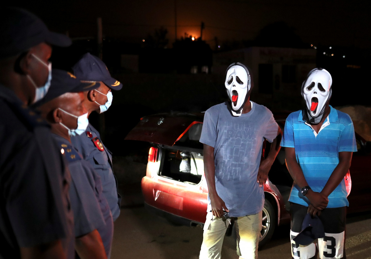 Police officers stop men wearing masks during a patrol as a nighttime curfew is reimposed amid a nationwide coronavirus disease (COVID-19) lockdown, in Pretoria, South Africa, January 9, 2021. REUTERS/Siphiwe Sibeko
