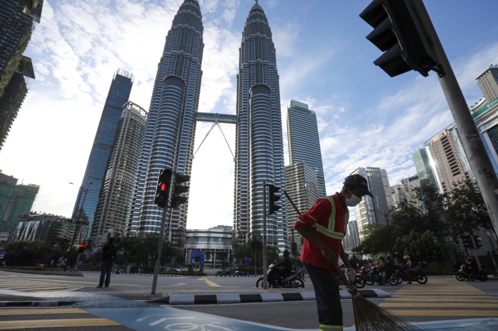 A street cleaner works in front of Petronas Twin Towers, amid the coronavirus disease (COVID-19) outbreak in Kuala Lumpur, Malaysia January 11, 2021. REUTERS/Lim Huey Teng