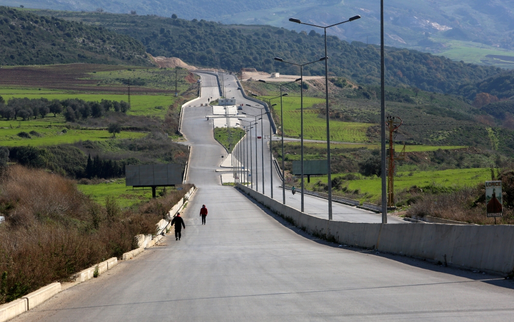 People walk along an empty road during a curfew to stem the rise in coronavirus disease (COVID-19) infections, in Nabatieh area, southern Lebanon January 10, 2021. REUTERS/Aziz Taher