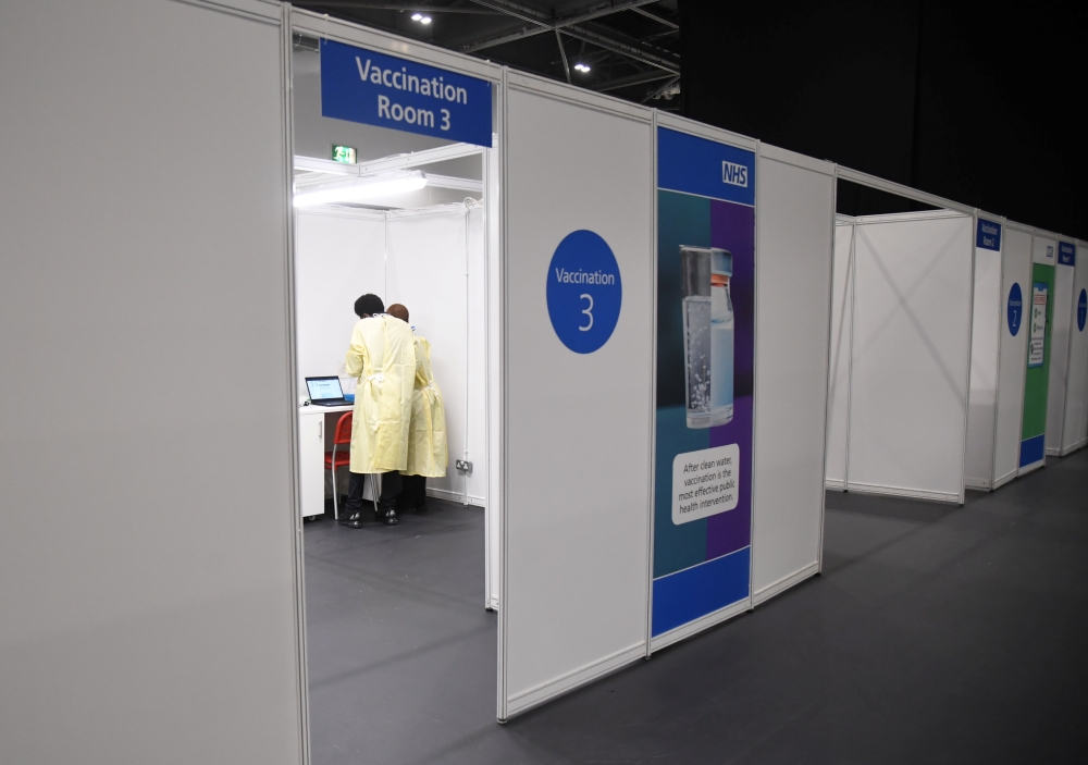 Members of the staff work at a NHS mass coronavirus vaccination centre in the Excel Centre in London, Britain January 11, 2021. Jeremy Selwyn/Pool via REUTERS