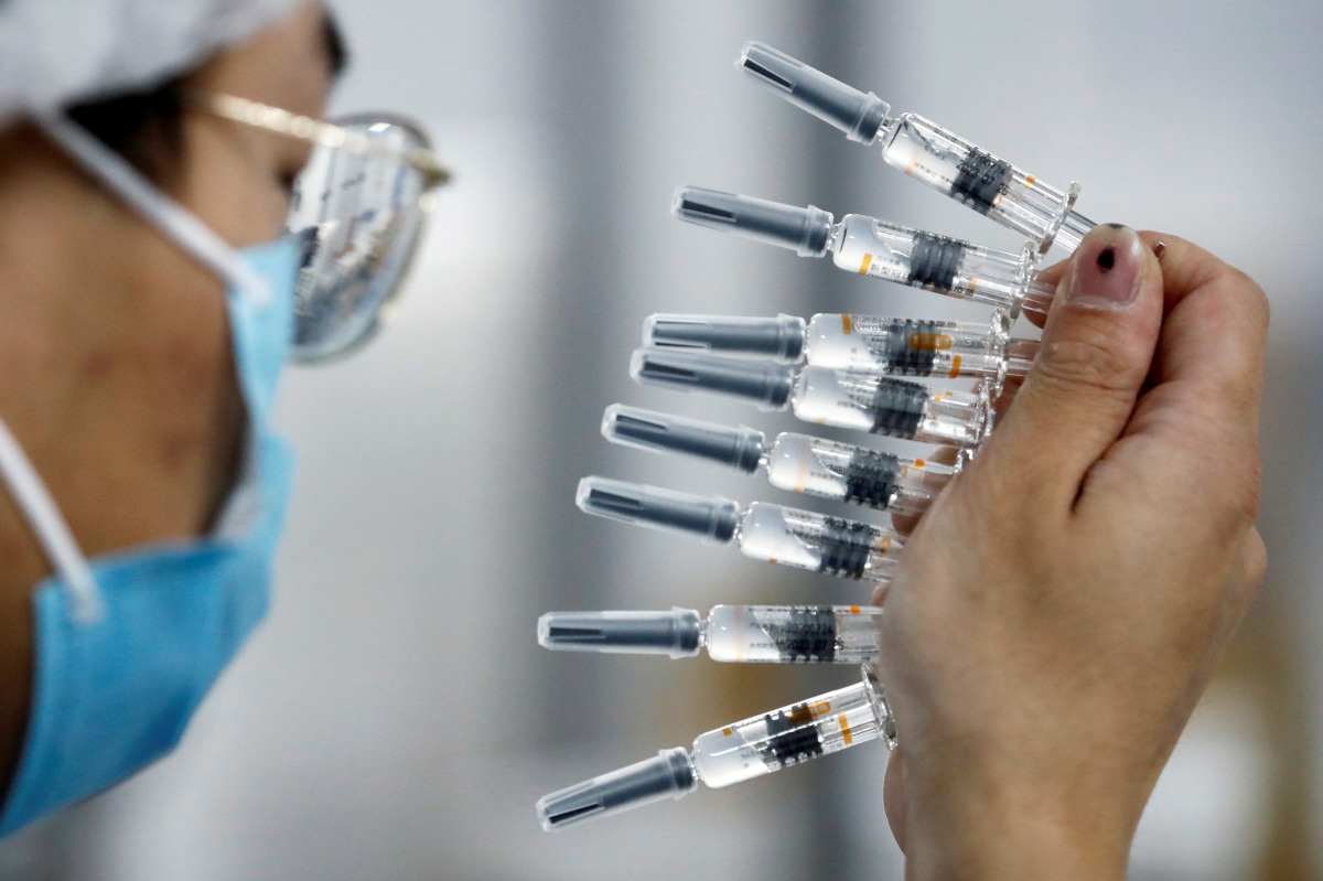FILE PHOTO: A worker performs a quality check in the packaging facility of Chinese vaccine maker Sinovac Biotech, developing an experimental coronavirus disease (COVID-19) vaccine, during a government-organized media tour in Beijing, China, September 24, 