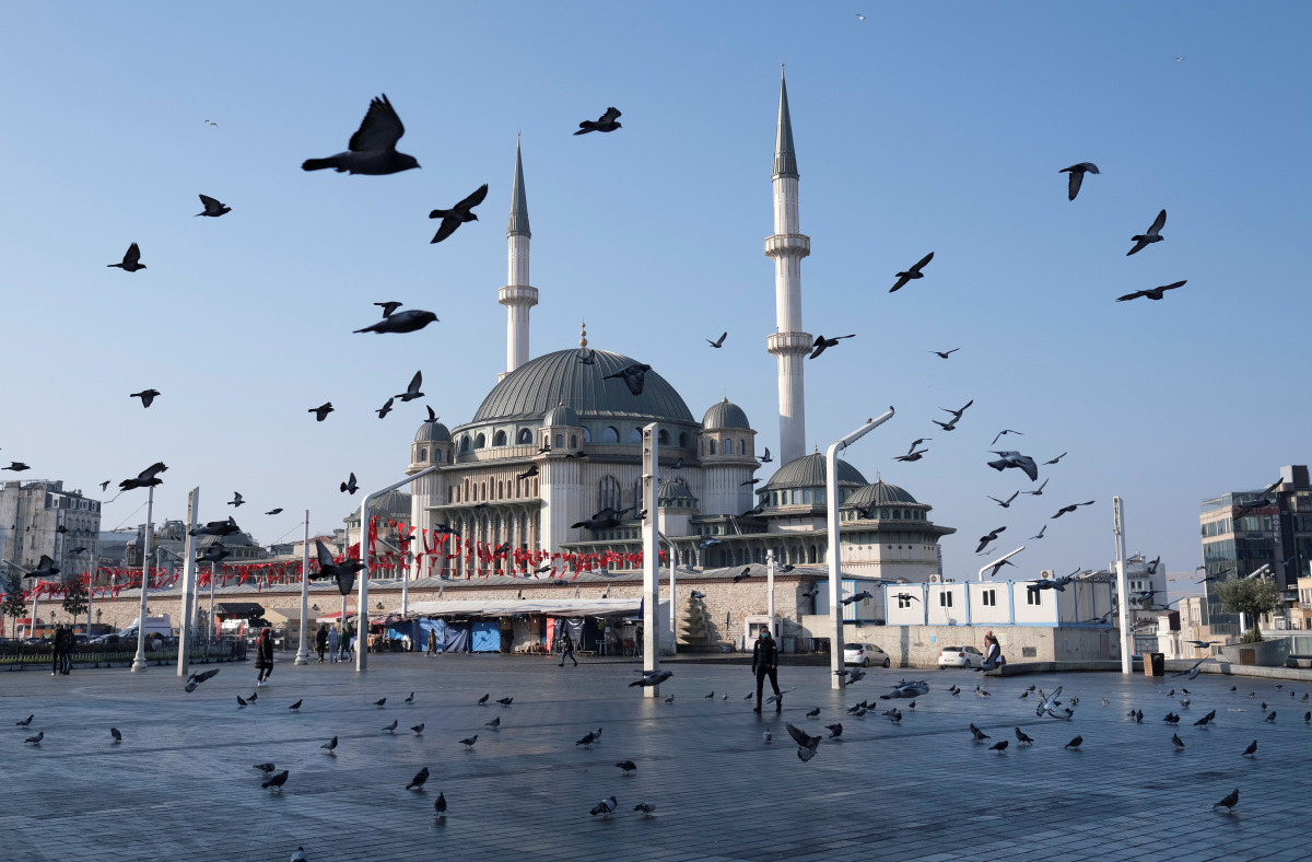 FILE PHOTO: Pigeons fly over the Taksim Square during a nation-wide weekend curfew which was imposed to prevent the spread of the coronavirus disease (COVID-19), in Istanbul, Turkey December 5, 2020. REUTERS/Murad Sezer/File Photo/File Photo
