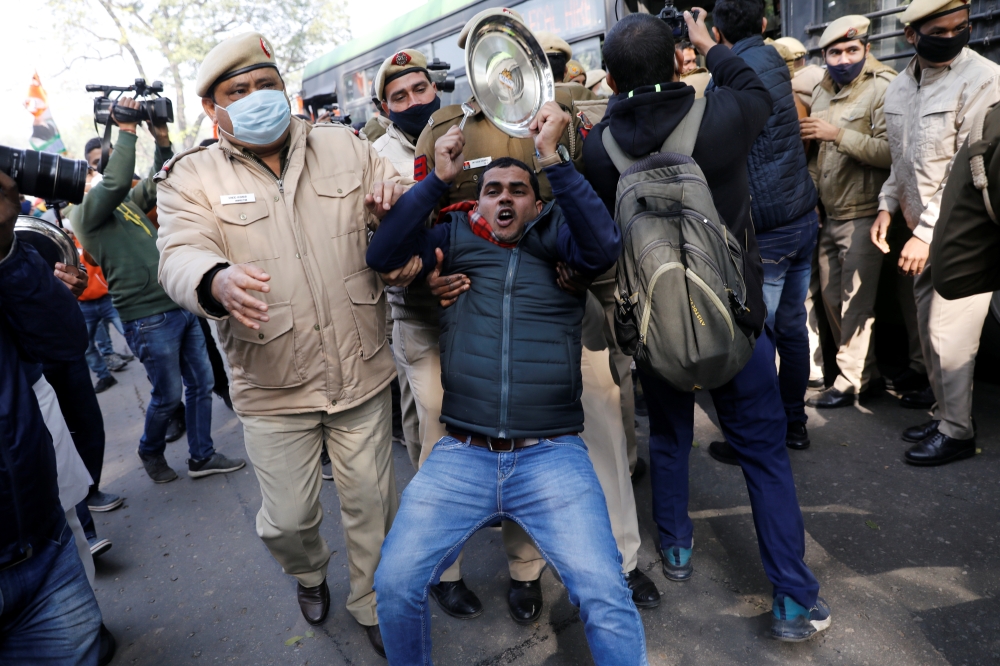 Police officers detain an activist of the youth wing of India's main opposition Congress party during a protest against new farm laws in New Delhi, India January 12, 2021. REUTERS/Adnan Abidi