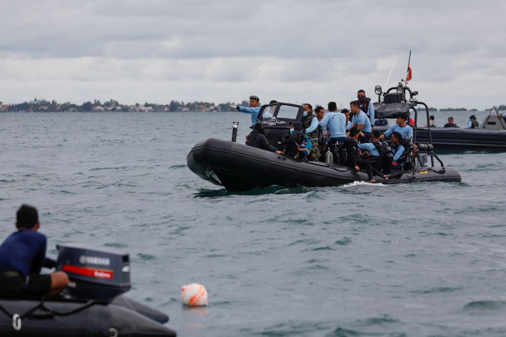 Indonesian navy divers stand on a rubber boat during the search and rescue operation for the Sriwijaya Air flight SJ 182, at the sea off the Jakarta coast, Indonesia, January 12, 2021. REUTERS/Willy Kurniawan