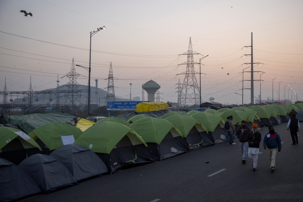 Farmers walk outside their tents at the site of a protest against new farm laws, at the Delhi-Uttar Pradesh border in Ghaziabad, India, January 11, 2021. REUTERS/Danish Siddiqui