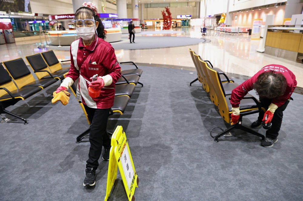 Staff members, wearing protective masks amid the coronavirus disease (Covid-19) pandemic, clean at the Taiwan Taoyuan International Airport in Taoyuan, Taiwan, January 7, 2021. Reuters/Ann Wang