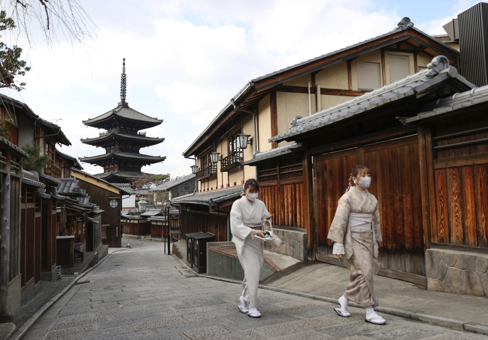 Two women walk on an unusually empty street during a state of emergency due to coronavirus disease (COVID-19) outbreak in Kyoto, Japan January 13, 2021.