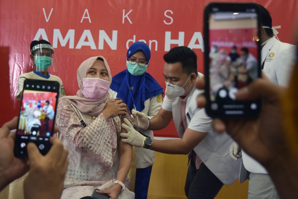 A doctor receives a dose of the Sinovac's vaccine as Indonesia begins mass vaccination for the coronavirus disease (COVID-19), at a hospital in Pekanbaru, Riau province, Indonesia, January 14, 2021 in this photo taken by Antara Foto. Antara Foto/Nova Wahy