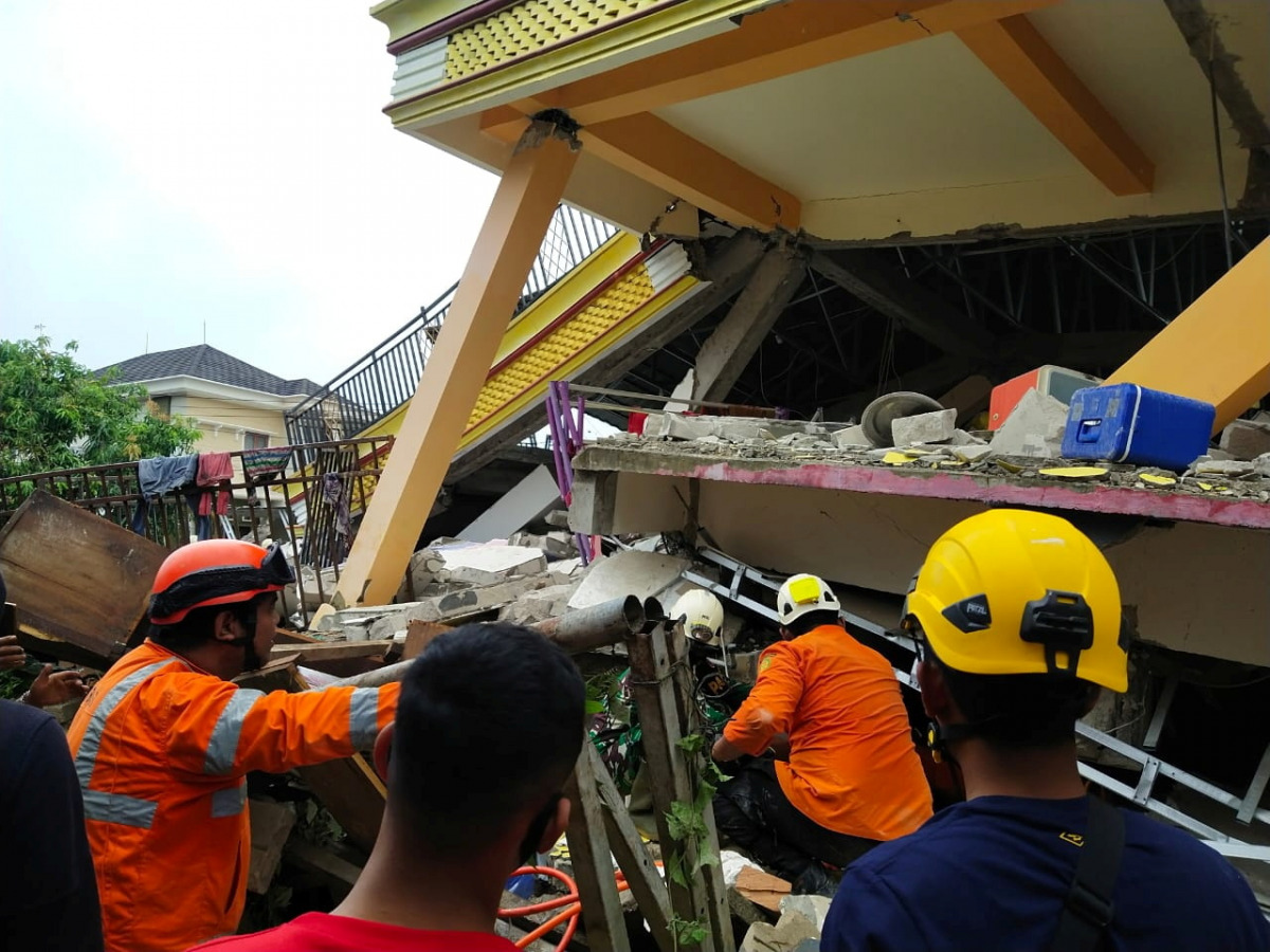 Members of a search and rescue agency team dig through rubble after an earthquake, in Mamuju, West Sulawesi Province, Indonesia January 15, 2021. Basarnas Sulbar/via REUTERS