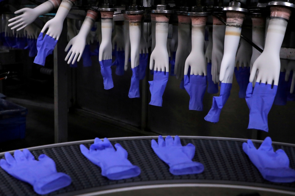 Newly-made gloves are pictured inside Top Glove factory in Shah Alam, Malaysia August 26, 2020. REUTERS/Lim Huey Teng/File Photo