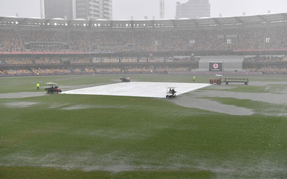 Water is seen pooling on the surface near the wicket during a rain delay on day two of the fourth test match between Australia and India at the Gabba in Brisbane, Australia, January 16, 2021. AAP Image/Darren England via Reuters 