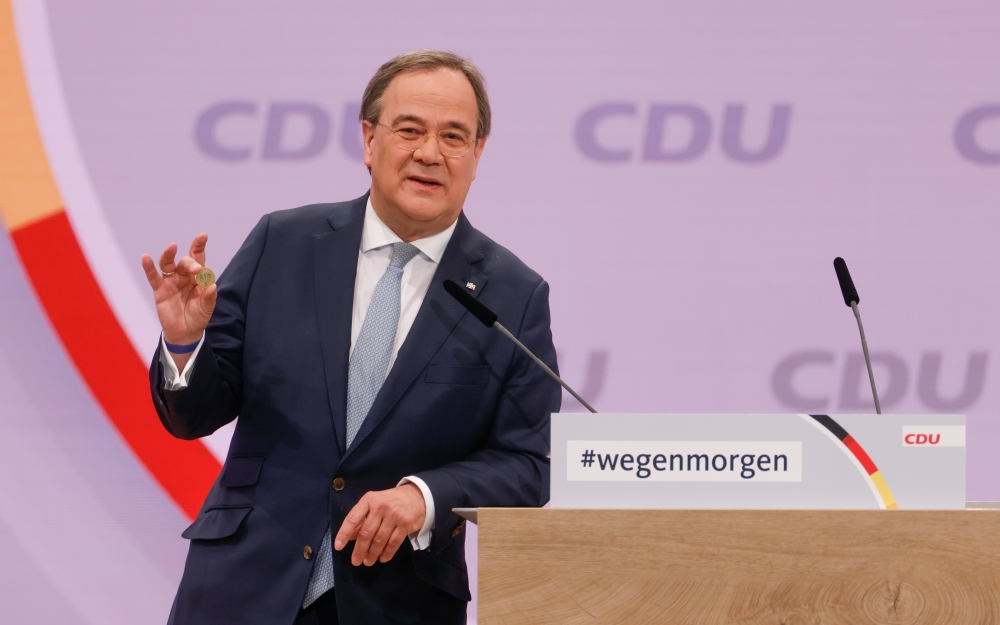 North Rhine-Westphalia's State Premier and candidate for the leader of the Christian Democratic Union (CDU) Armin Laschet shows a luck coin offered to him by his father in Berlin, Germany January 16, 2021. Odd Andersen/Pool via Reuters