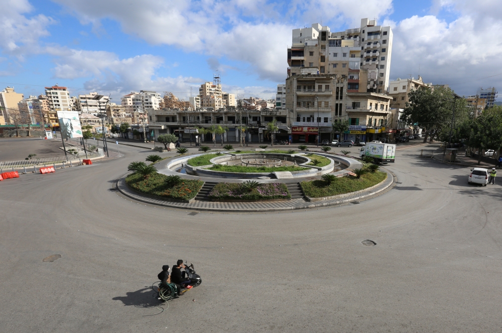 People ride on a motorbike along an empty road, as Lebanon tightened lockdown and introduced a 24-hour curfew to curb the spread of the coronavirus disease (COVID-19) in Sidon, Lebanon, January 15, 2021. REUTERS/Aziz Taher