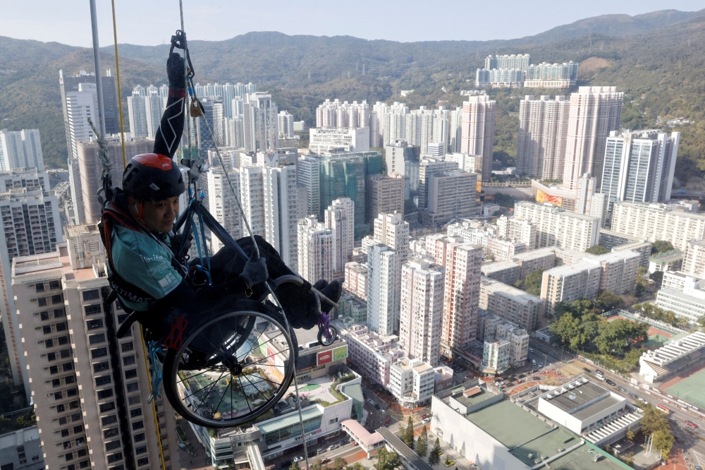 Lai Chi-wai, a paraplegic climber, attempts to climb the 320-metre tall Nina Tower using only his upper body strength, in Hong Kong, China January 16, 2021. On this attempt, Lai completed 250-meters (75/f), as he faced strong winds. Picture taken January 