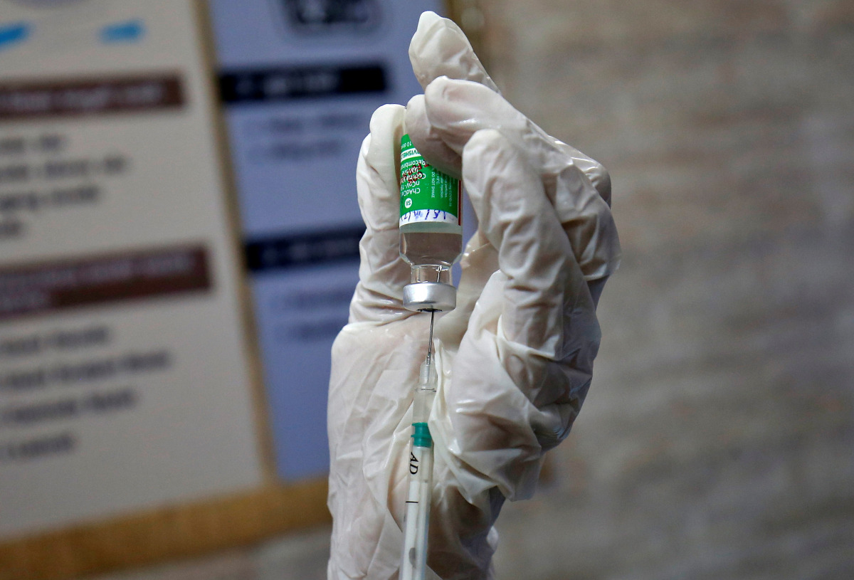 A paramedic fills a syringe with COVISHIELD, a COVID-19 vaccine manufactured by Serum Institute of India, before administering it to a colleague during one of the world's largest COVID-19 vaccination campaigns at a health centre in Ahmedabad, India, Janua