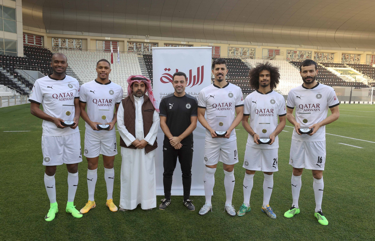 Al Sadd stars Abdelkarim Hassan, Akram Afif, Khoukhi Boualem, Pedro Miguel, and Baghdad Bounedjah posing for a photograph with Xavi Hernandez and an official after they were honoured by the club for being selected in Qatar Players Association's Best XI fo