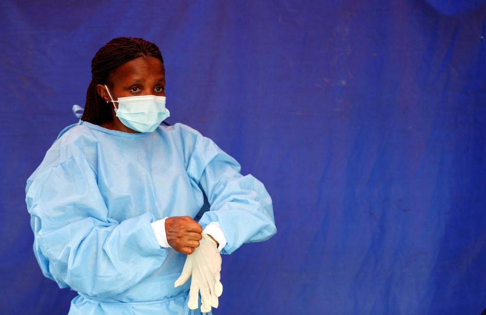 A health worker wears protective clothing as she prepares for testing travellers for the coronavirus disease amid a nationwide Covid-19 lockdown, at the Grasmere Toll Plaza, in Lenasia, South Africa, January 14, 2021. Reuters/Siphiwe Sibeko/File Photo 