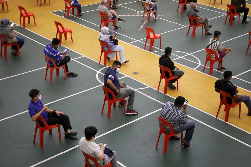 People wait to be tested for the coronavirus disease (COVID-19) in Petaling Jaya, Malaysia January 18, 2021. REUTERS/Lim Huey Teng