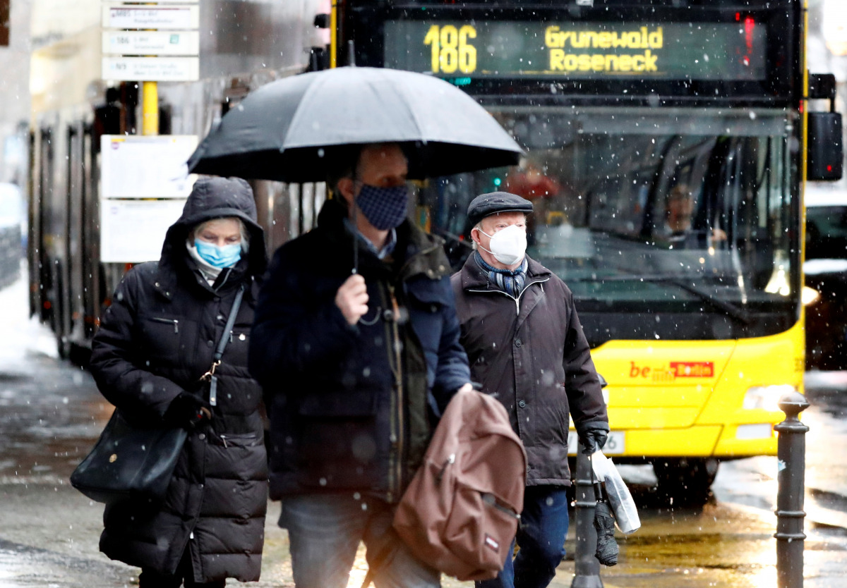 People wear face masks as they walk past a bus during lockdown due to the coronavirus disease (COVID-19) pandemic in Berlin, Germany, January 19, 2021. REUTERS/Fabrizio Bensch
