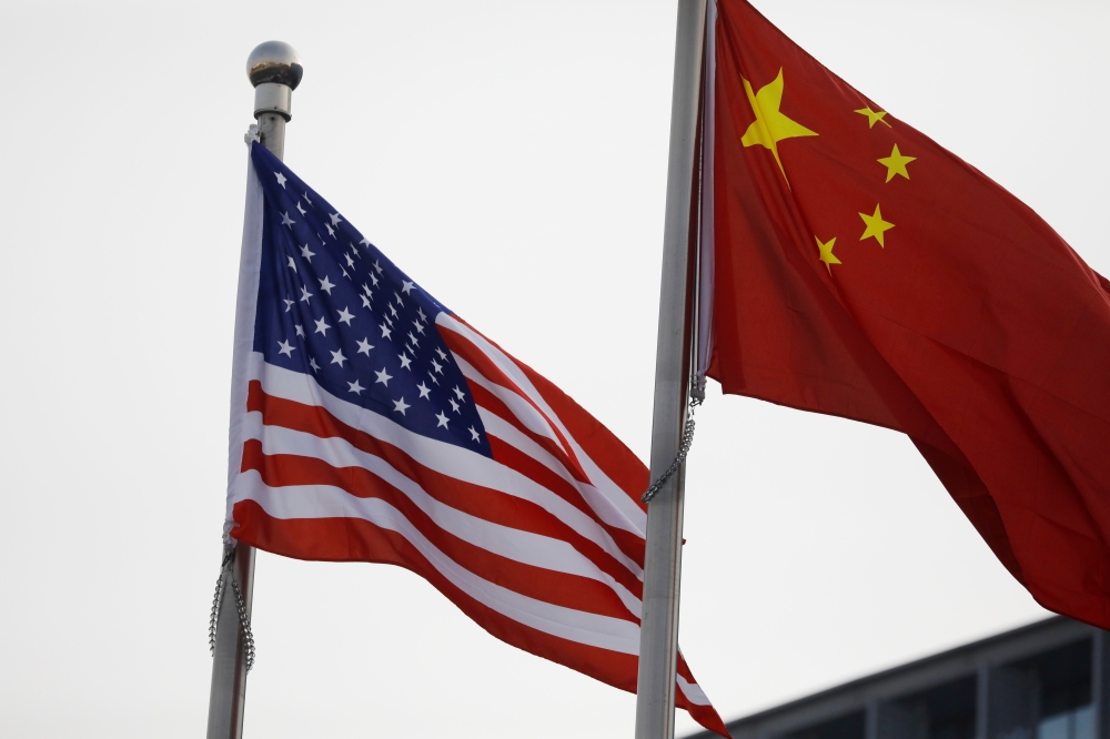 Chinese and US flags flutter outside the building of an American company in Beijing, China January 21, 2021. REUTERS/Tingshu Wang